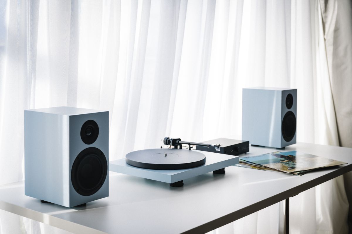 Modernes HiFi-System mit Plattenspieler und zwei Lautsprechern auf einem weißen Tisch