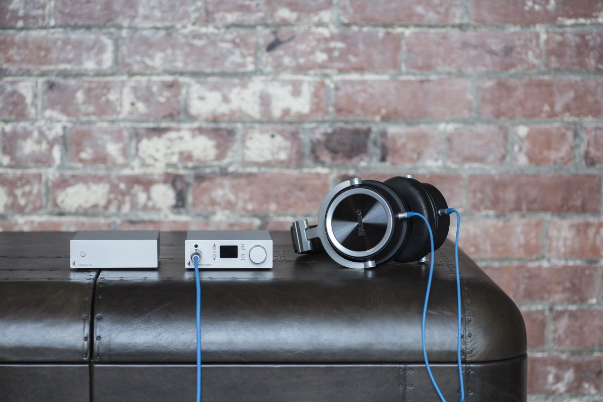 Kopfhörerverstärker-Setup auf einem Ledertisch vor Backsteinwand